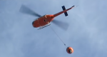 Picture of the underside of a helicopter with a bucket attached for water drops.