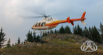 Helicopter hovering over a landing area with banner announcing new across top right corner.