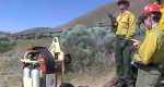 Group of wildland firefighters stand near a crash rescue kit.