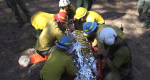 Photo of firefighters preparing to airlift an injured person on a backboard.