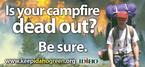 Billboard Graphic that shows a hiker walking away from a burning forest and the text reads "Is you Campfire Dead Out?  Be sure"